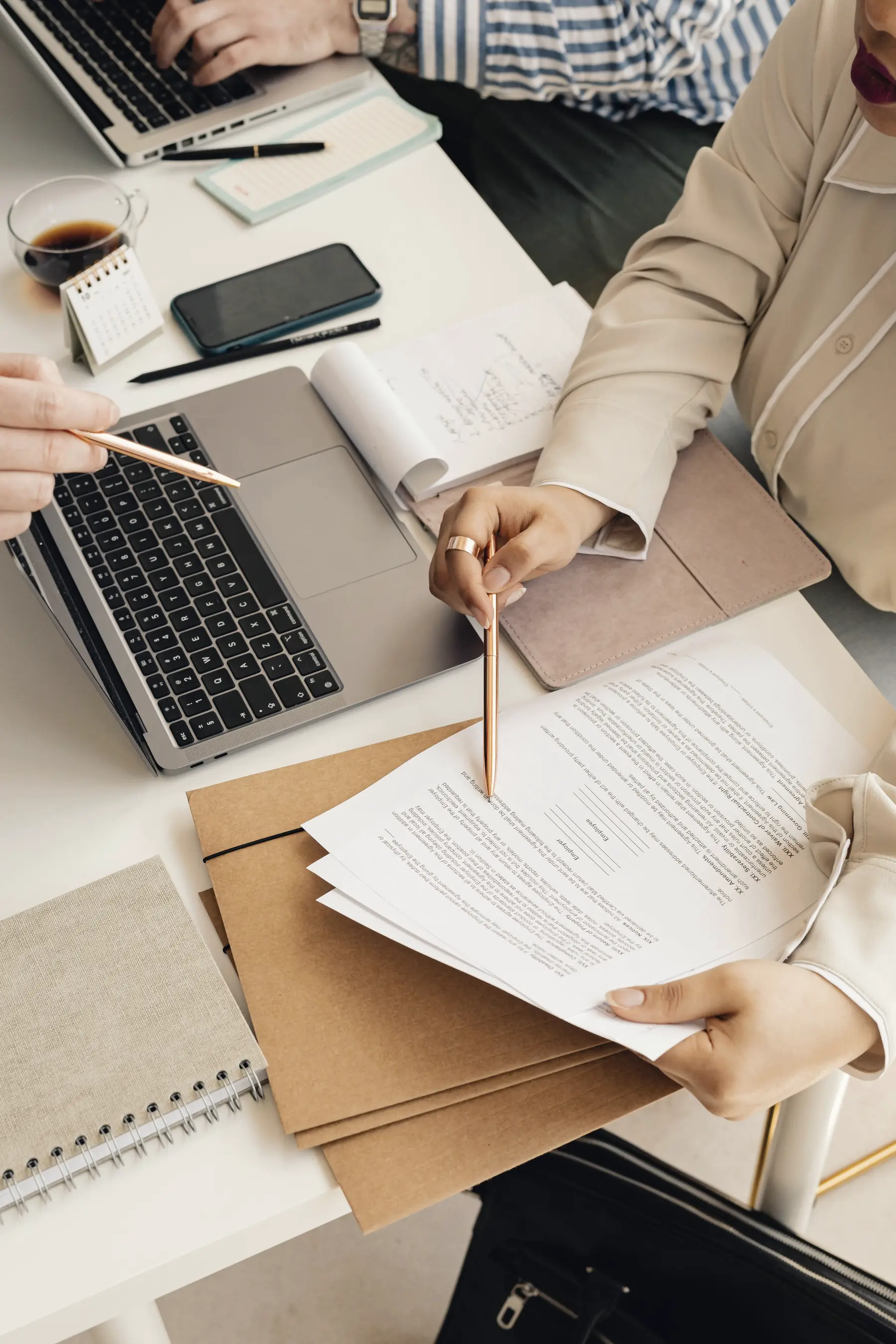 Hands reviewing printed contract documents on a desk